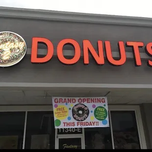 a donut shopfront with a sign that says grand opening this friday