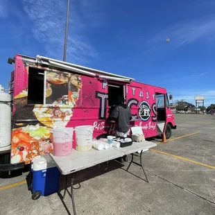 a pink food truck parked in a parking lot