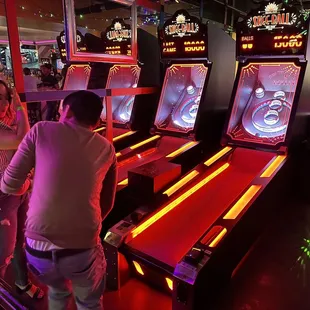 two people playing a game of pinball