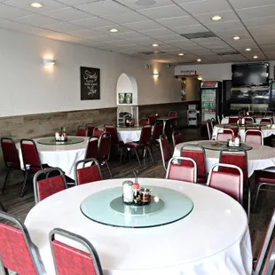 tables with white tablecloths and red chairs