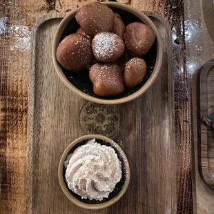 a bowl of doughnuts and a bowl of whipped cream