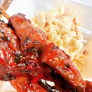 a plate of ribs and macaroni and cheese