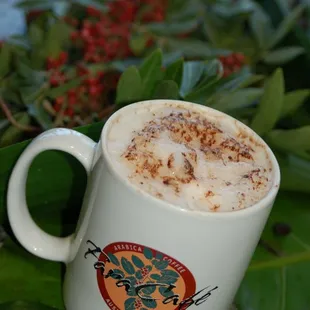 a cup of coffee on a leafy table
