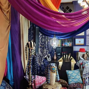 a room with a variety of fabrics hanging from the ceiling