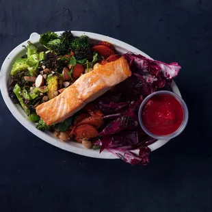 a plate of food with salmon and vegetables