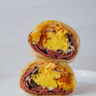 Pastrami Breakfast Burrito. Pasture Raised Eggs, Pastrami, Swiss Cheese, Fingerling Potatoes, Horseradish Aioli on Flour Tortilla.