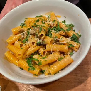 a person holding a plate of pasta