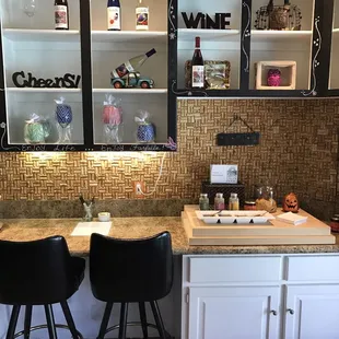 a kitchen counter with two chairs