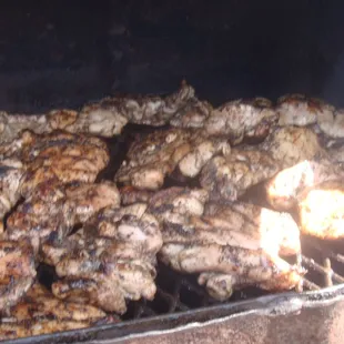 Boneless Jerk Chicken on the Grill, smoke with pieces of Pimento Wood.