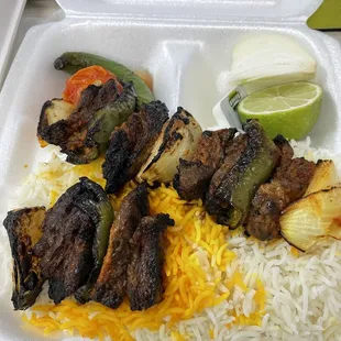 a tray of food with rice, meat and vegetables