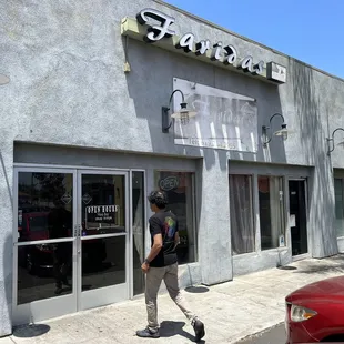 a man walking in front of a restaurant