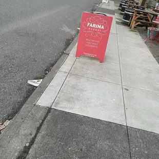 a red sign on the sidewalk