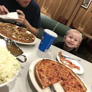 a man and a child eating pizza