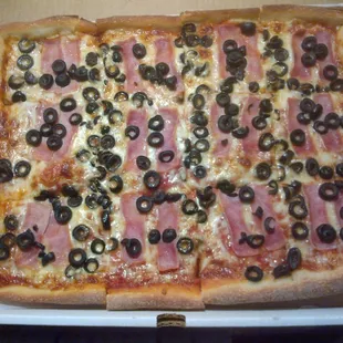 a pizza with olives and ham
