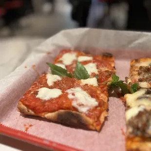 two slices of pizza on a red tray