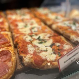 a variety of pizzas on display