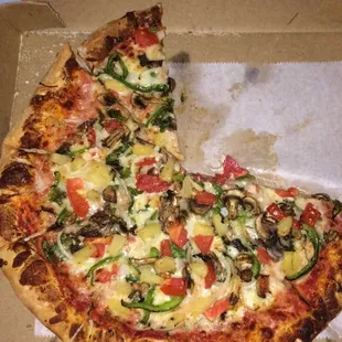 A partially eaten large veggie pizza. Delicious!