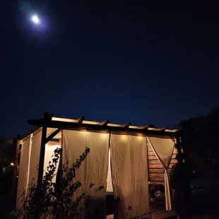 a man standing in front of a shed at night