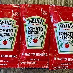 three packets of heinz tomato ketchup
