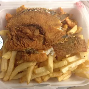 fried fish and french fries in a styrofoam container