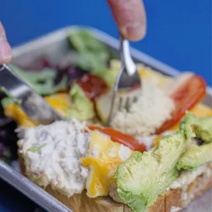 a person cutting into a sandwich