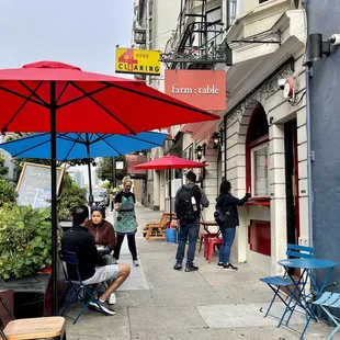 a group of people sitting under umbrellas
