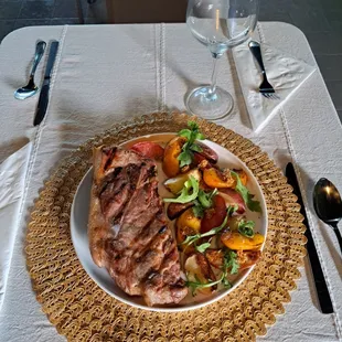 Grilled pork steak with peach, tomato and potatoes at Farmacy Grill