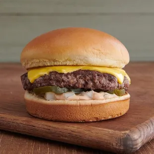 a cheeseburger on a wooden cutting board