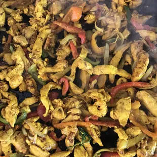 chicken and vegetables cooking on a grill