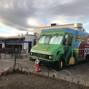 a green food truck parked in a parking lot