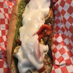 a hot dog covered in cheese and vegetables