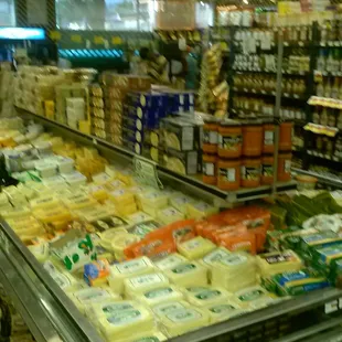 Shelves With Sauces, Oils, Various Jars &amp; Cooler With Cheese Selections