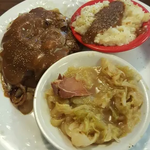 a plate of meat, mashed potatoes, and gravy