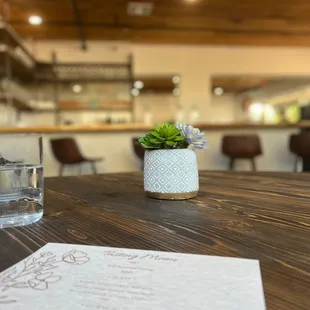 a table with a menu and a glass of water