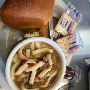 a bowl of soup and a roll