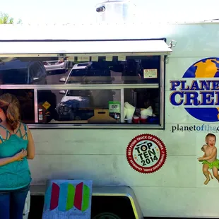 a woman standing in front of a food truck