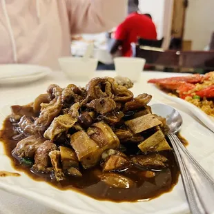 a plate of food with a woman in the background
