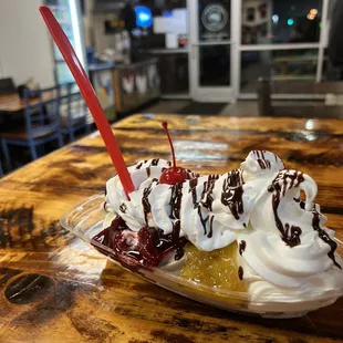 a banana split with whipped cream and chocolate syrup