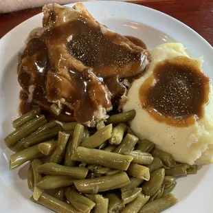 Open face roast beef sandwich with gravy, mashed potatoes with gravy, and green beans