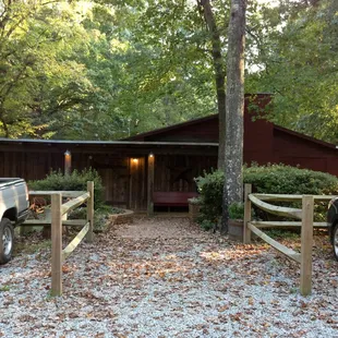 two pickup trucks parked in front of a cabin