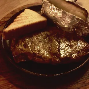 Ribeye and baked potato with Texas toast.