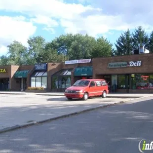 a red car parked in front of a deli
