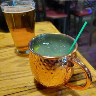a copper mug with a green drink in it