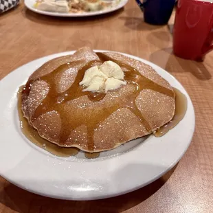 a plate of pancakes with butter and syrup