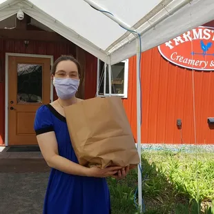 Laura bringing out delicious groceries for our "curbside" pickup.  Pre-order via our new e-store!