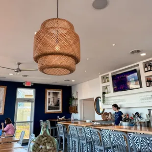 a restaurant with blue walls and a wicker light fixture