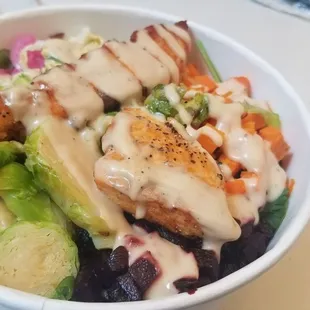 Salmon quinoa brussel sprout beet carrot pickled onion cilantro slaw mixed green bowl