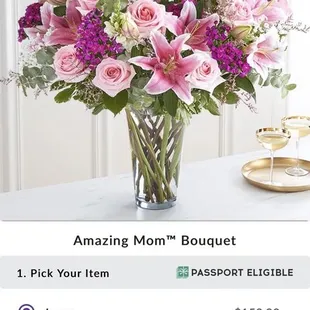 The large arrangement with a dozen pink roses, lilies and carnations along with white puffs.