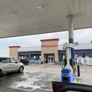 a gas station with a car at the pump