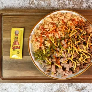 Fiesta Taco Bowl made with equal portions spanish rice and seasoned taco beef. Served with pinto beans for extra protein